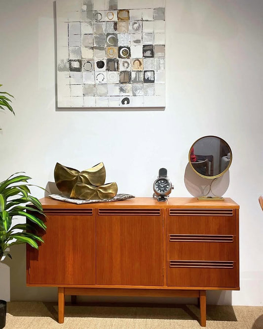 Expert restoration of a Wrighbilt wooden sideboard with decorative items in a room with a wall art piece. Professional refurbishment by Covesmore Solutions, Sydney's best furniture restorers.