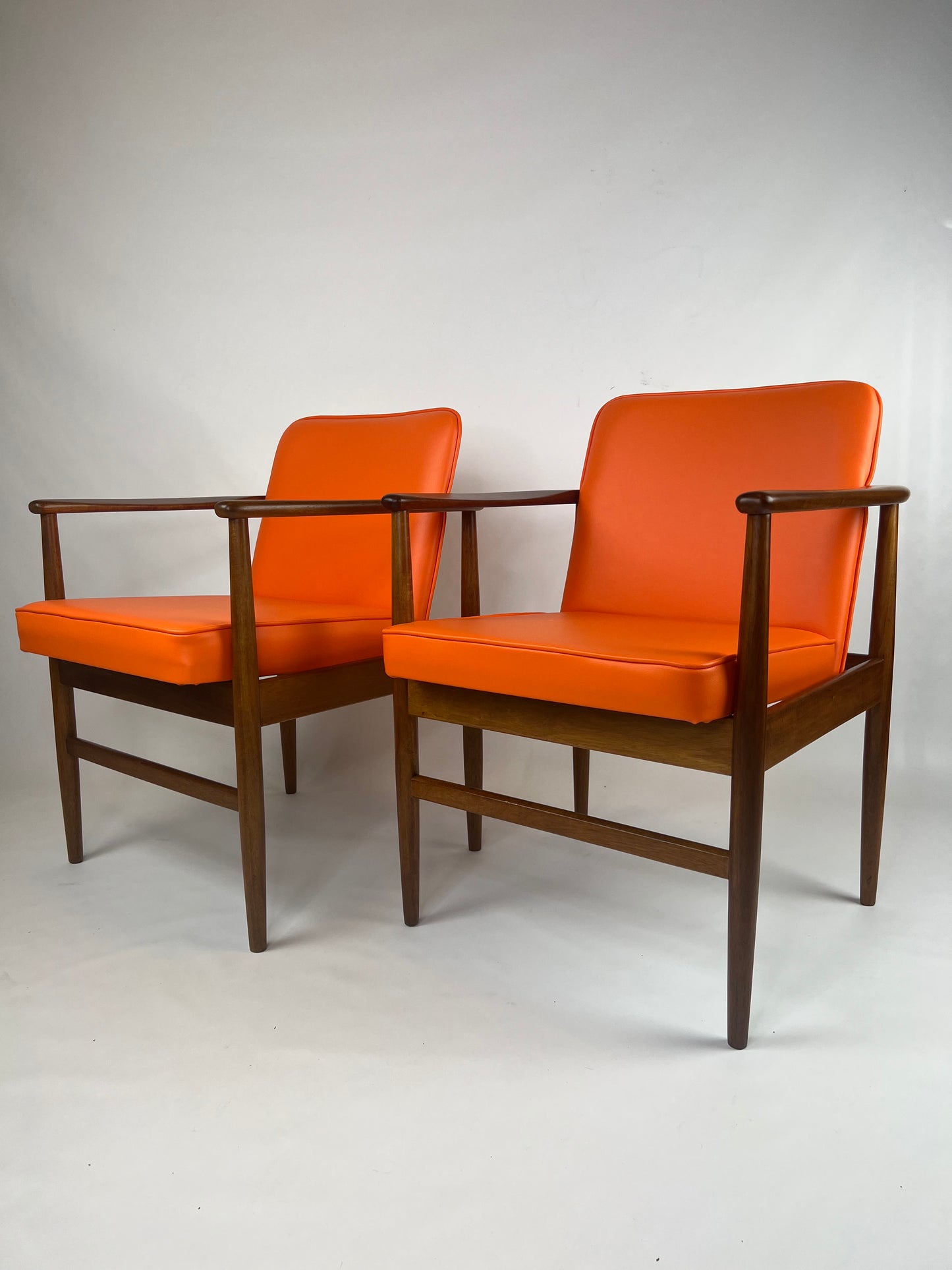 Side vire of a pair of Arthur Stutchbury chairs, restored and reupholstered in Orange upholstery. These chairs are available for sale.