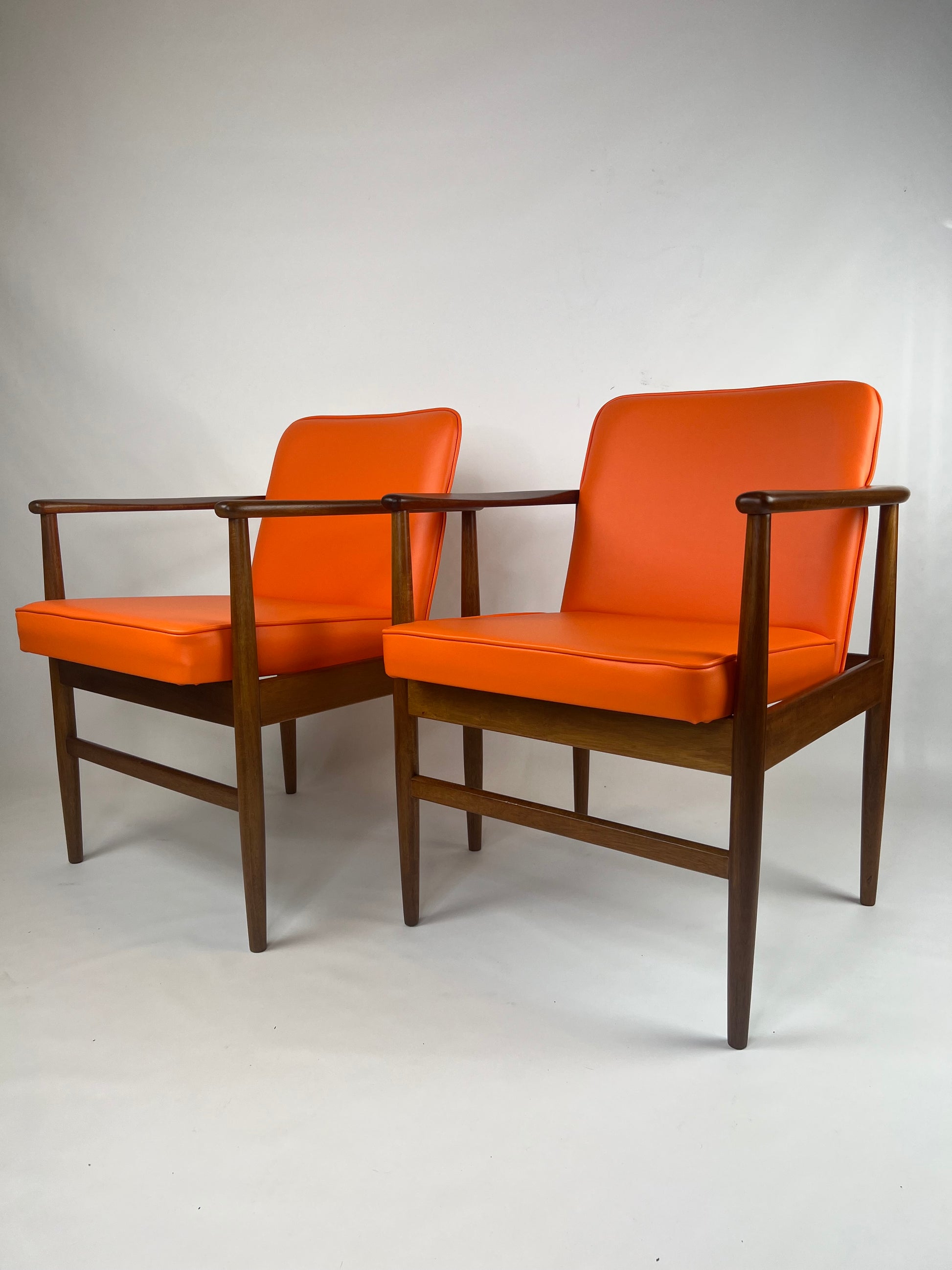 Side vire of a pair of Arthur Stutchbury chairs, restored and reupholstered in Orange upholstery. These chairs are available for sale.