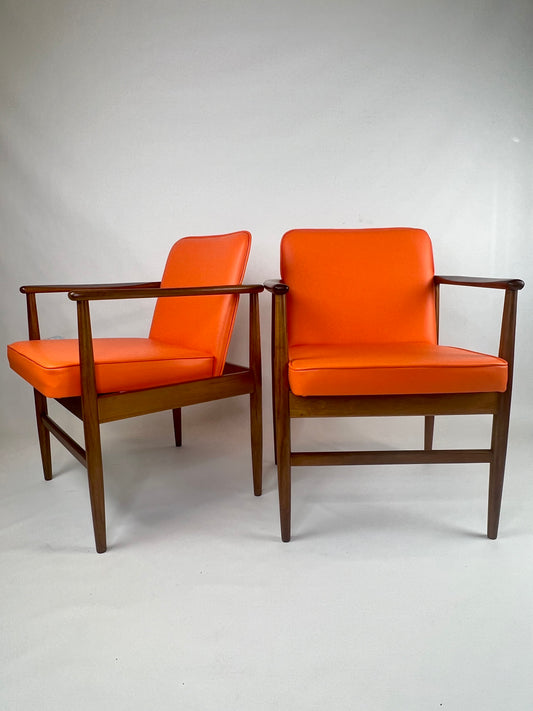 A pair of Arthur Stutchbury chairs, restored and reupholstered in Orange upholstery. These chairs are available for sale in Sydney Showroom.