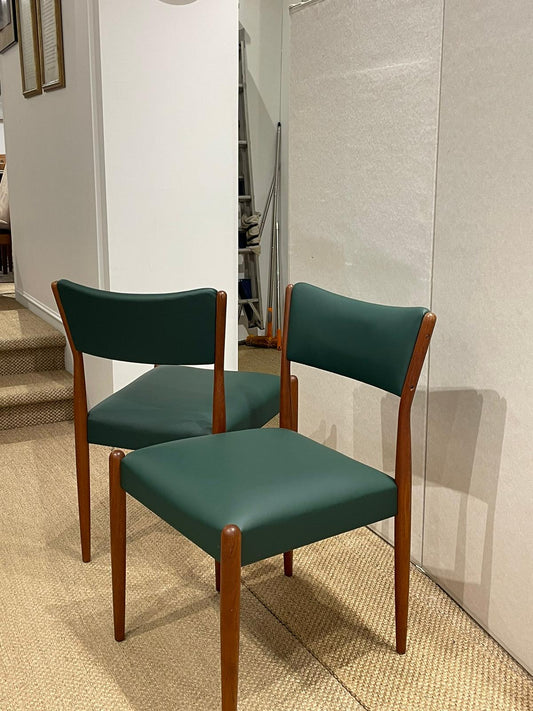 Two Parker 97 chairs with wooden frames and green leather in a room setting. Parker Furniture in Sydney.