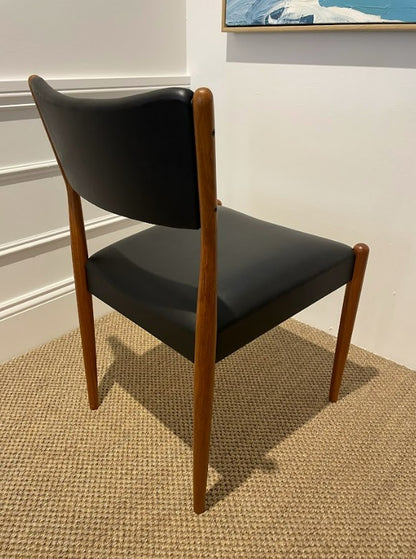 Parker 97 Chair with Black leather with wooden legs on a textured floor. Parker Furniture For Sale In Willoughby.