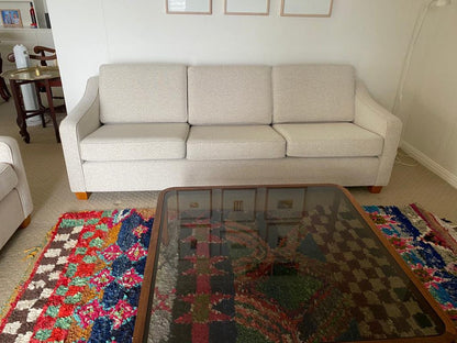 Beige Parker 3-seater sofa in a living room with a colorful rug and glass coffee table. Parker Furniture online by the Ex Parker People™.