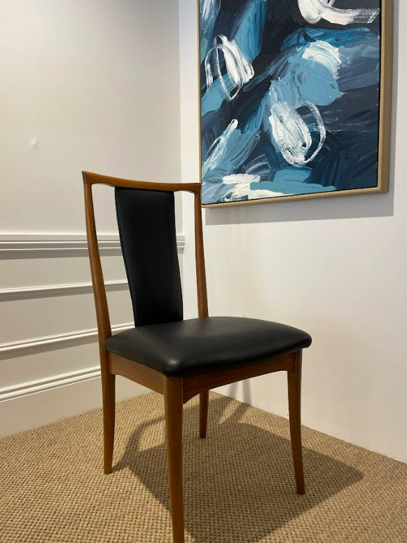 Parker 60 wooden chair with black leather seat in a room with abstract art on the wall. Parker furniture for Sale.