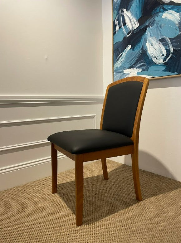Parker Chair 92, Wooden frame with black leather seat in a room with a abstract painting on the wall. Available online or in Willoughby at Parker furniture showroom.