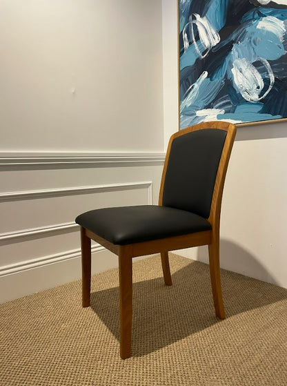 Parker Chair 92, Wooden frame with black leather seat in a room with a abstract painting on the wall. Available online or in Willoughby at Parker furniture showroom.