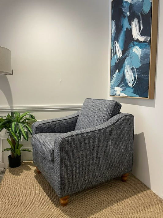 Gray armchair in a room with a abstract painting on the wall. This armchair is part of the macquarie range by Parker furniture, available for viewing in Willoughby.