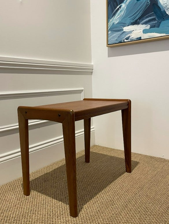 Wooden coffee table against a white wall with a piece of abstract art above it. Ex Parker People™