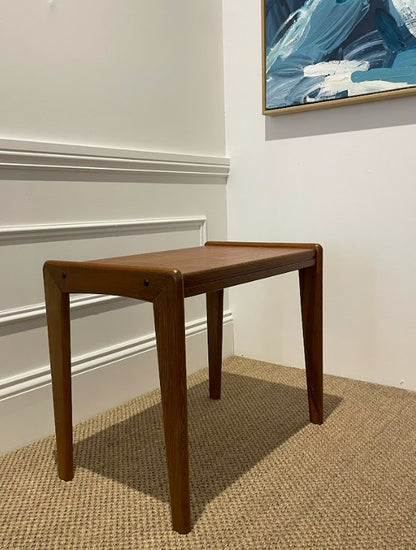 Wooden coffee table against a white wall with a piece of abstract art above it. Ex Parker People™