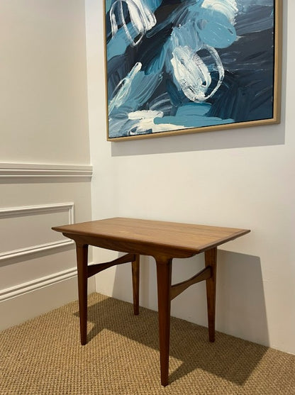 Wooden table in a room with abstract art on the wall. Refurbished completely by the Ex Parker People™ and available for purchase in NSW or online.