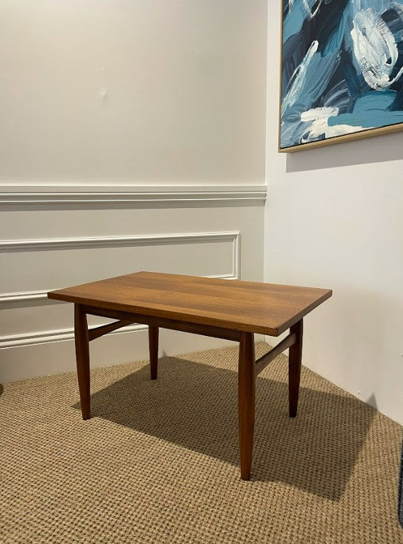 Wooden table in a room with a painting on the wall. Available for purchase. Ex Parker People™