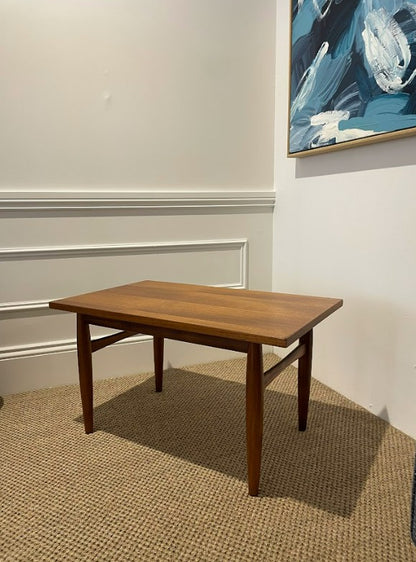 Wooden table in a room with a painting on the wall. Available for purchase. Ex Parker People™