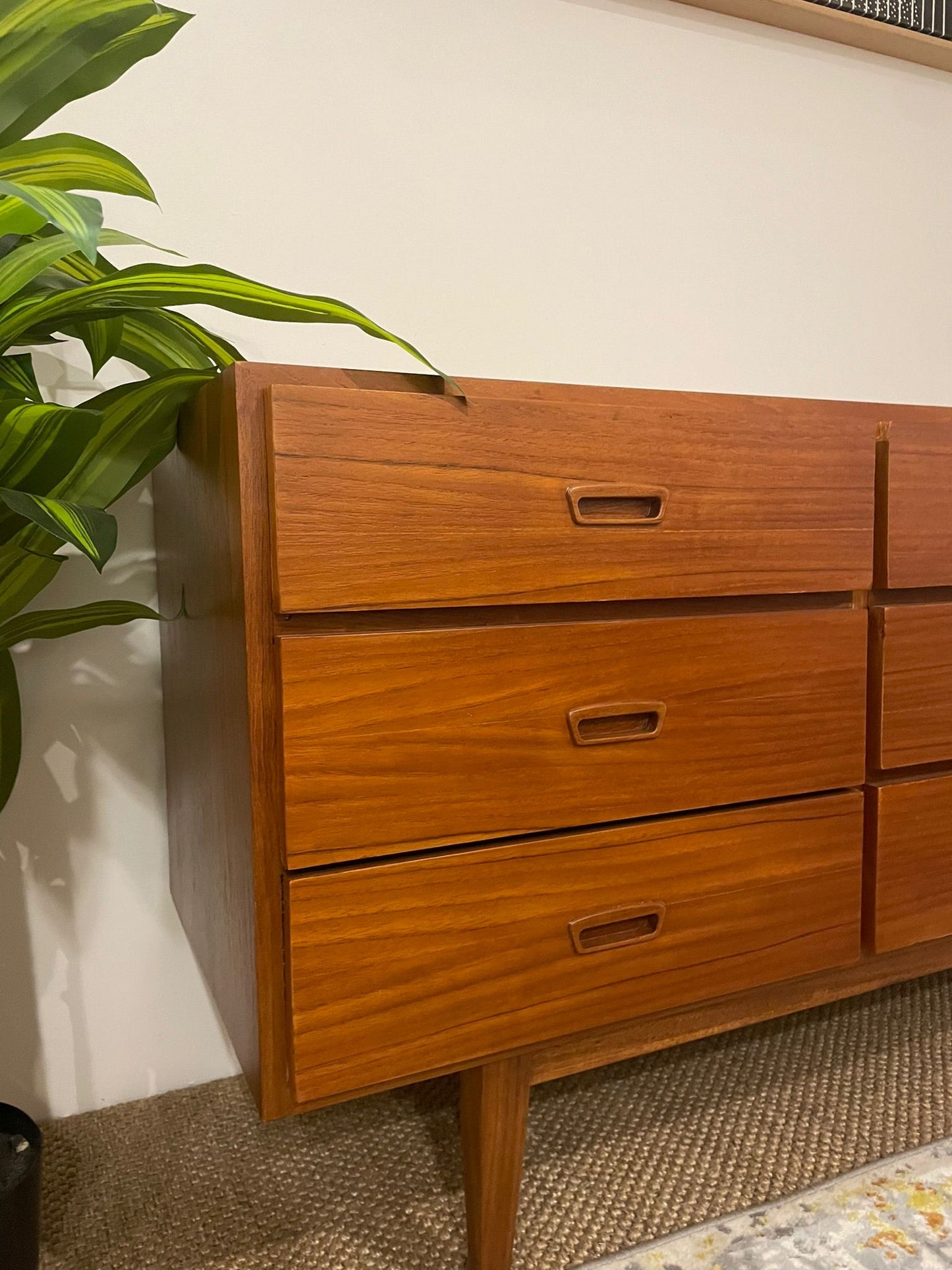 Parker wooden dresser with four drawers next to a plant on a carpeted floor. Available for Purchase online or at Willoughby Parker Showroom.
