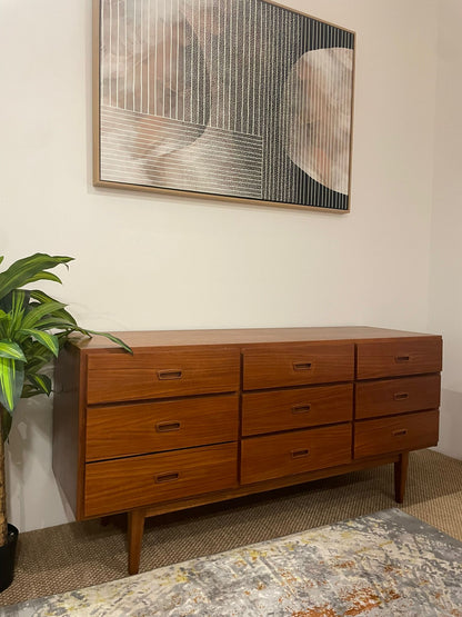 Parker dresser with multiple drawers in a room with a plant and abstract art on the wall in Parker Showroom. Available for purchase in Willoughby.
