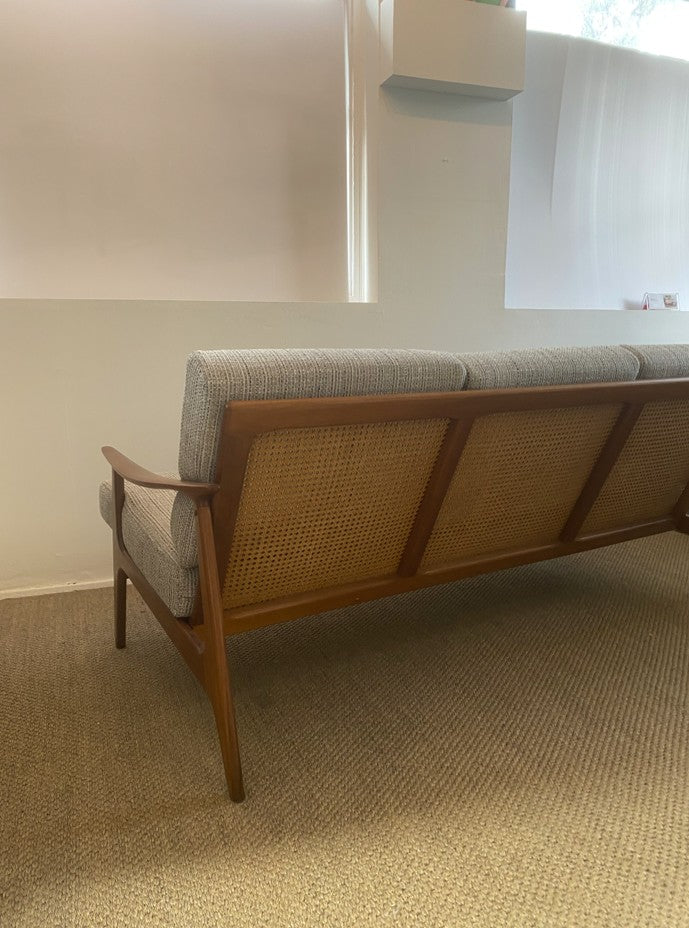 Restored Parker 158 three-seater lounge with sculpted teak frame and woven rattan back panels.