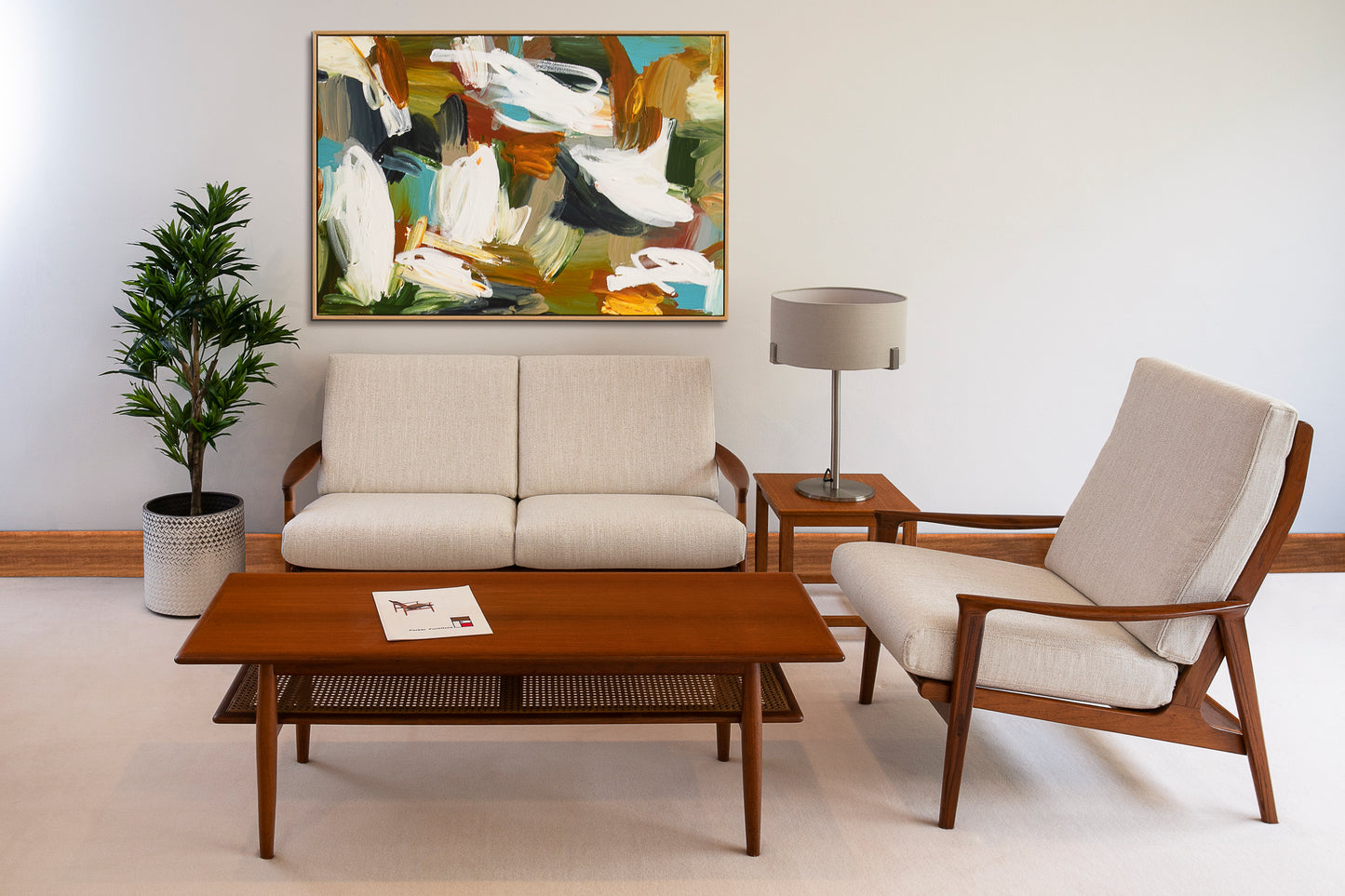 A living room setting featuring a beige Parker Lounge 160 Series sofa and an armchair, arranged around a wooden coffee table. A abstract painting hangs above the sofa, and a lamp and plant complement the scene. Ex Parker People™